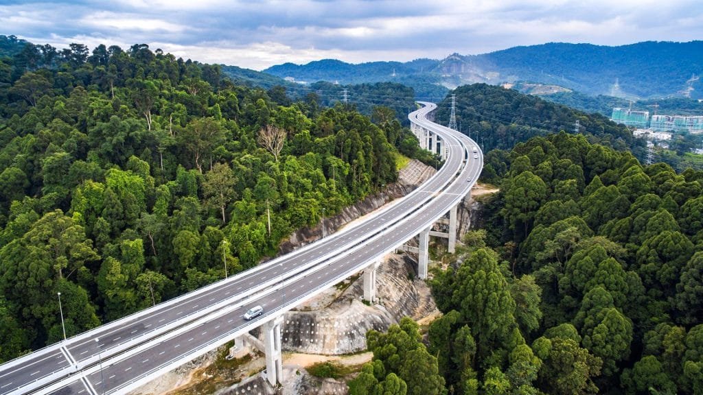 Elevated Malaysian highway winding through rainforest hills