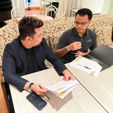 Luxamana representative and client reviewing partnership documents